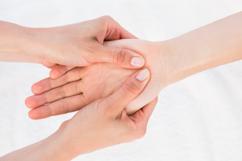 Physiotherapist doing hand massage in medical office