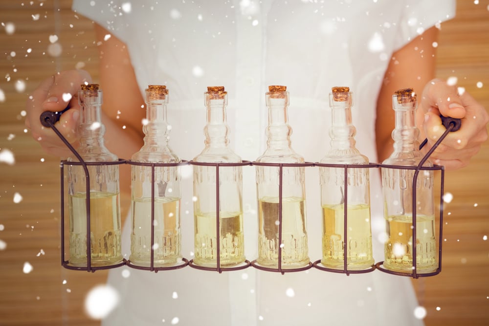 Snow against woman holding bottles of oil massage